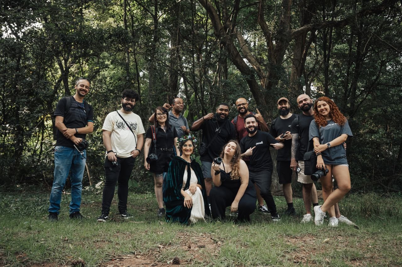 A diverse group of photographers enjoying an outdoor meetup in a lush forest setting.