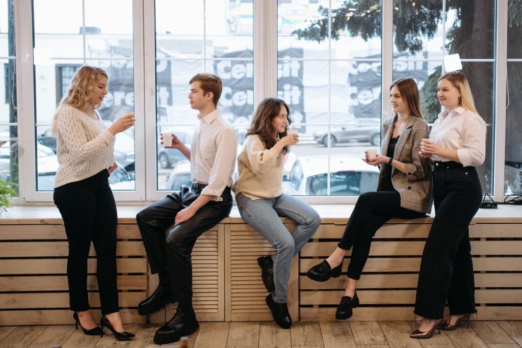 Group of colleagues enjoying a coffee break inside a modern office.